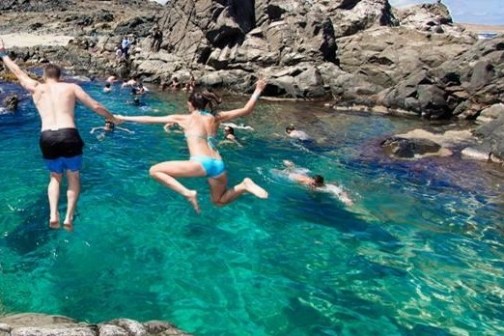 a group of people swimming in a pool of water